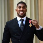 Anthony Joshua poses with his medal after being appointed an Officer of the Order of the British Empire