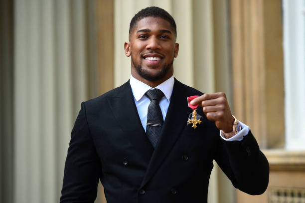 Anthony Joshua poses with his medal after being appointed an Officer of the Order of the British Empire